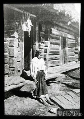 
Mujer junto a una casa rural
