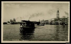 Tarjeta postal de vista panorámica de Venecia desde el mar con barco de recreo a vapor al frente.