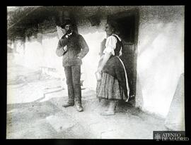 Hombre y mujer delante de la puerta de una casa rural